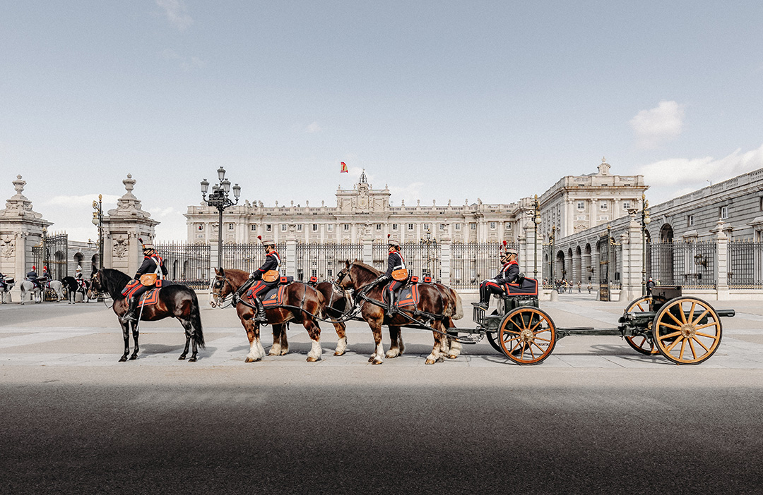 Exterior view of the Royal Palace of Madrid (Palacio Real) under a clear blue sky.
